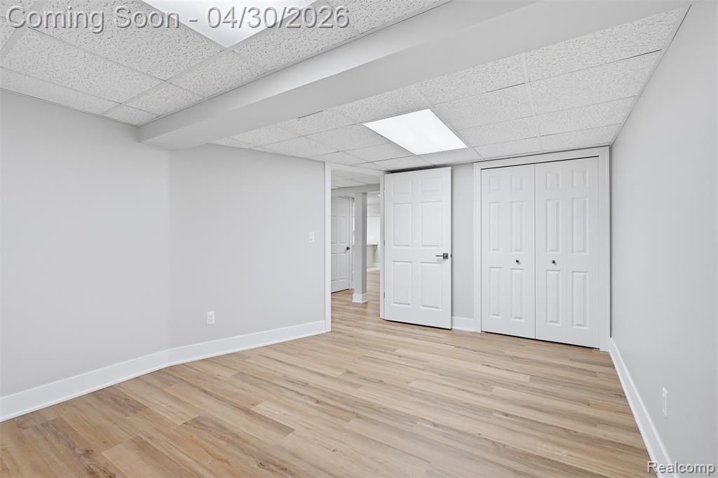 Lower level unfurnished guest bedroom option or storage, a drop ceiling, and a closet