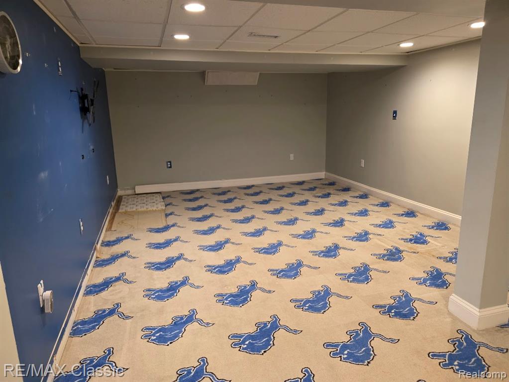 Empty room with recessed lighting and a drop ceiling