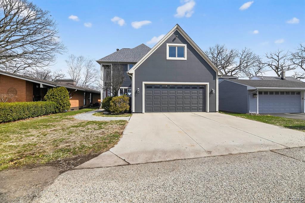 View of front facade featuring a garage and concrete driveway