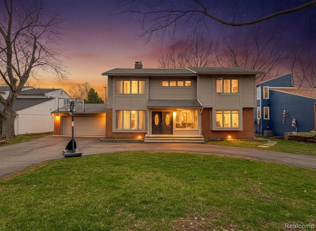 Contemporary facade featuring a prominent double-door entry with sidelights, brick accents, and a two-car garage