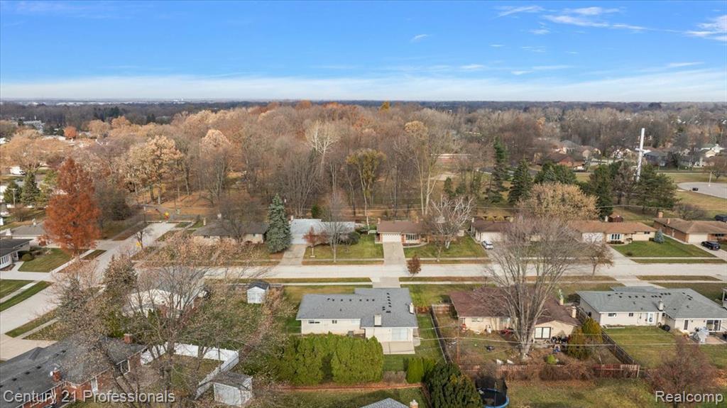 View of property location featuring nearby suburban area and a forest