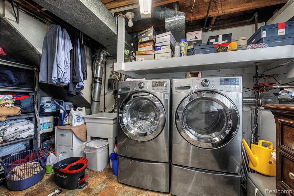 Laundry area featuring stone finish flooring and washer and dryer