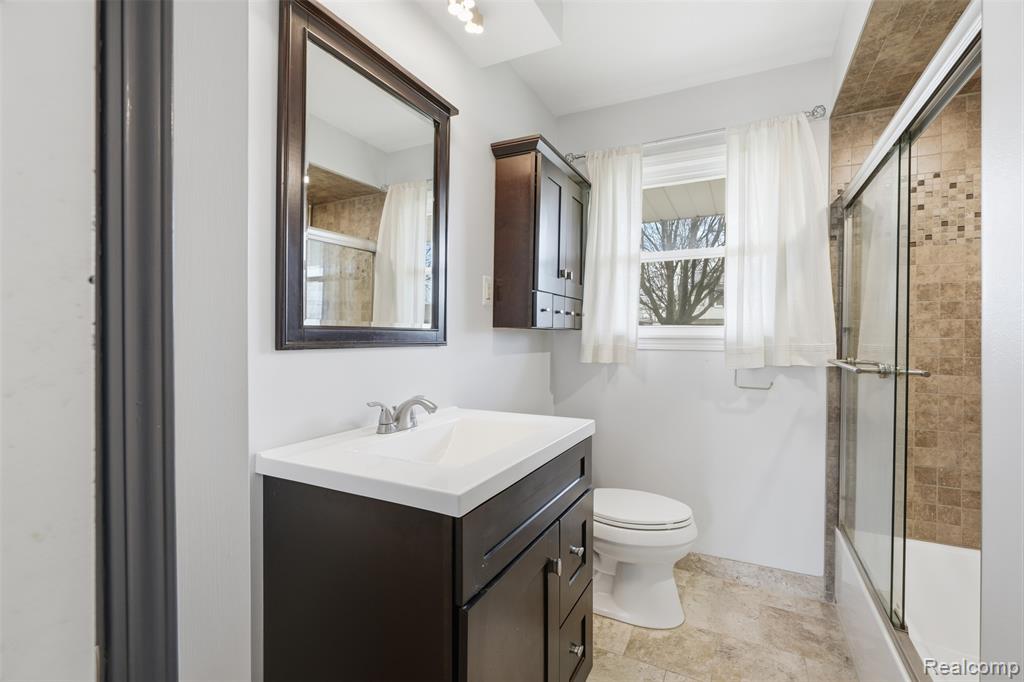 Full bathroom with vanity and shower / bath combination with glass door