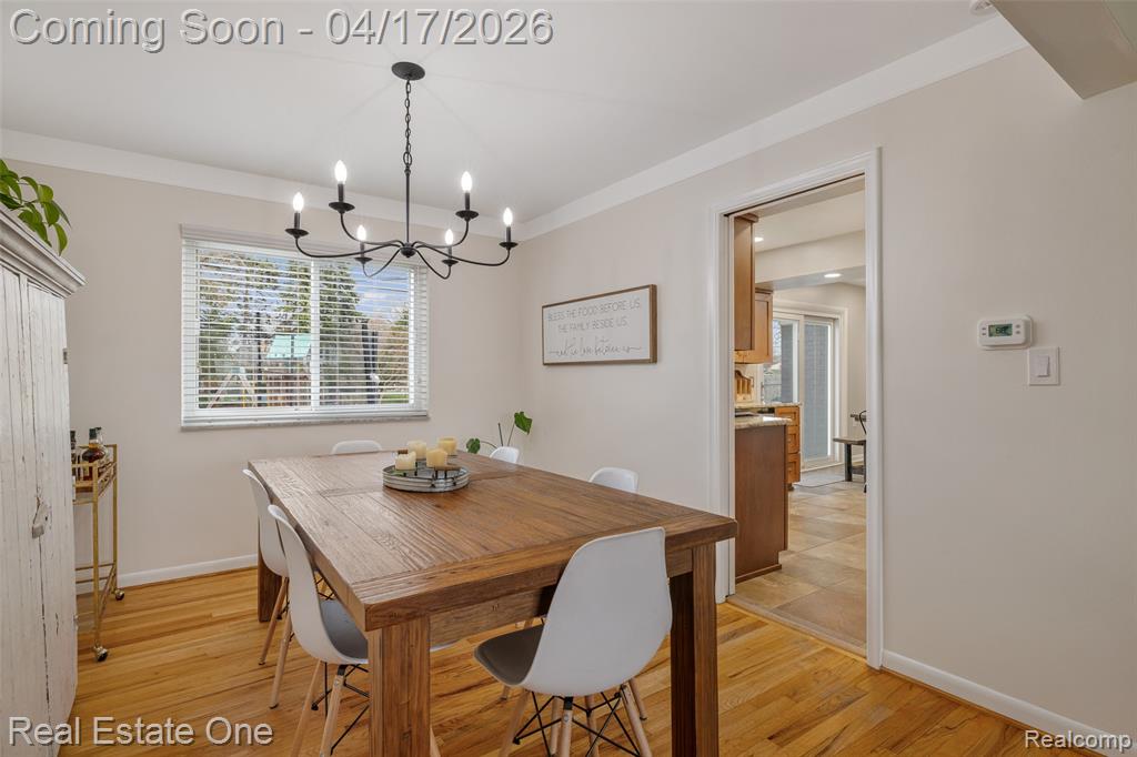 Dining area with light wood-style flooring and suspended lighting