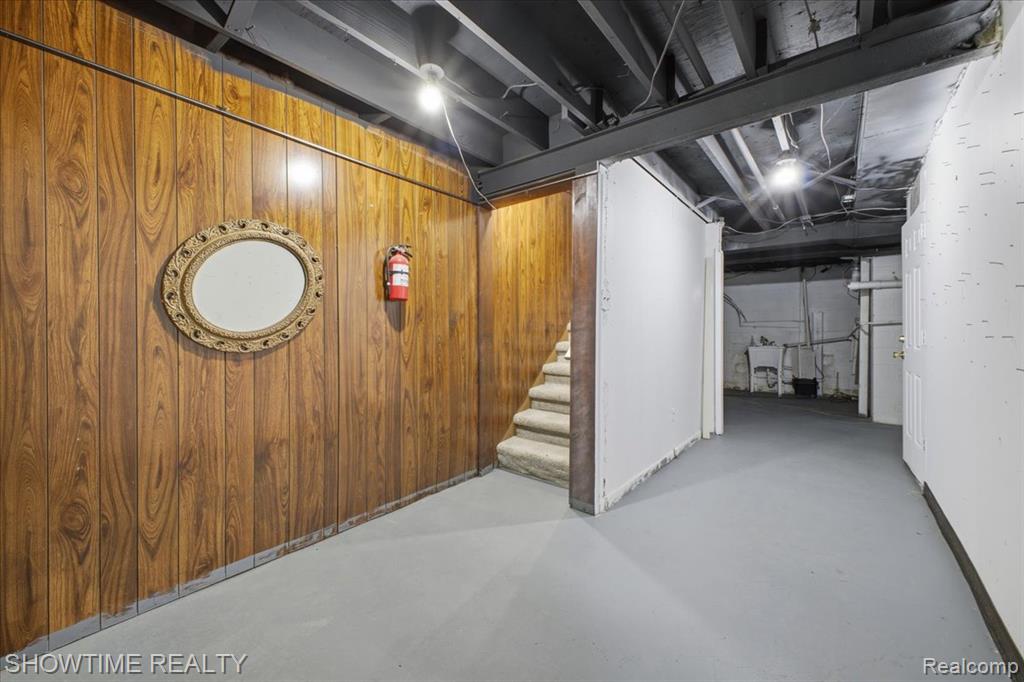 Finished basement featuring stairs and wooden walls