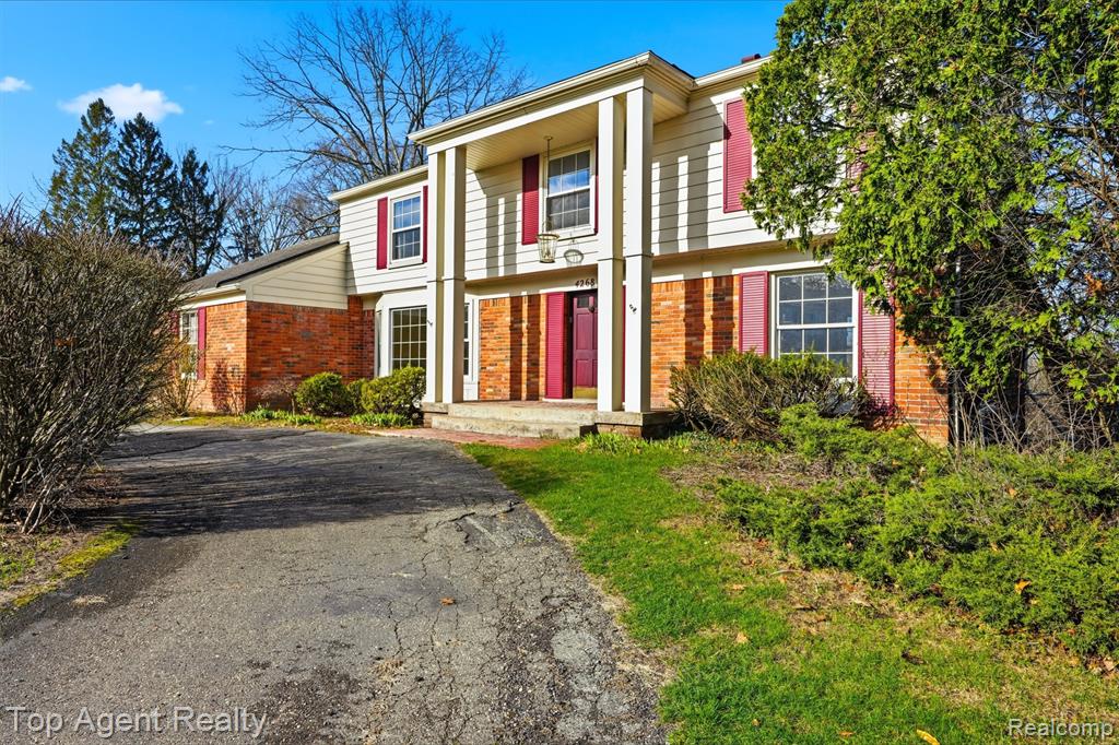 View of front of house featuring brick siding and driveway