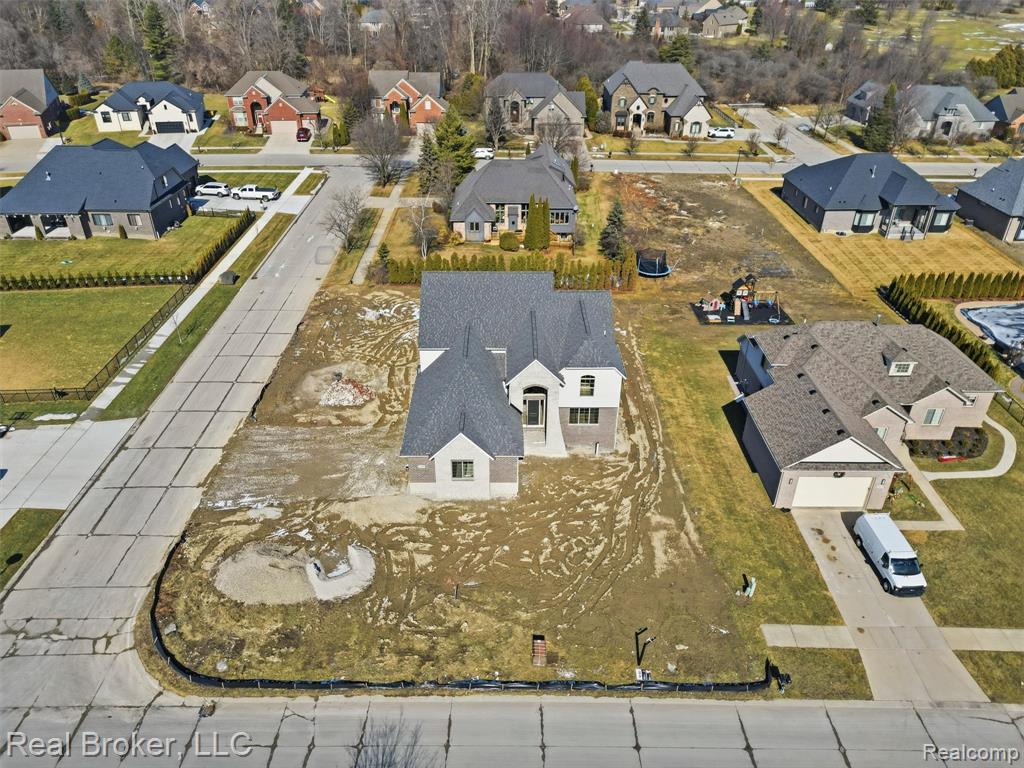 Aerial view of property and surrounding area featuring nearby suburban area