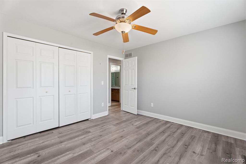 Unfurnished bedroom featuring ceiling fan, a closet, and wood finished floors