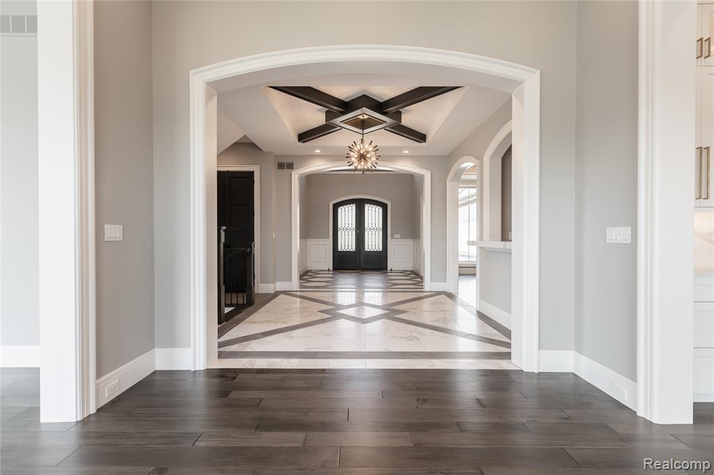 Entryway featuring inlaid floor details, dark wood-style flooring, french doors, and recessed lighting