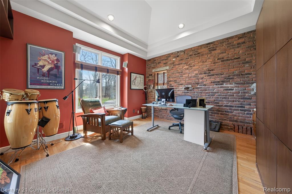 Office area with brick wall and light wood-style floors