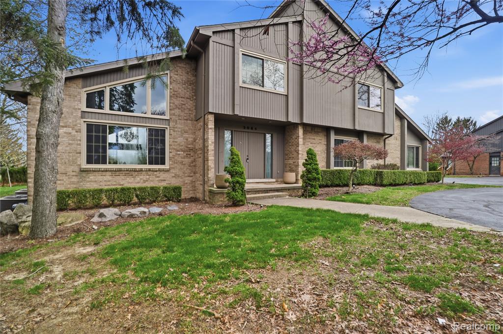 View of front of house with brick siding and a front lawn