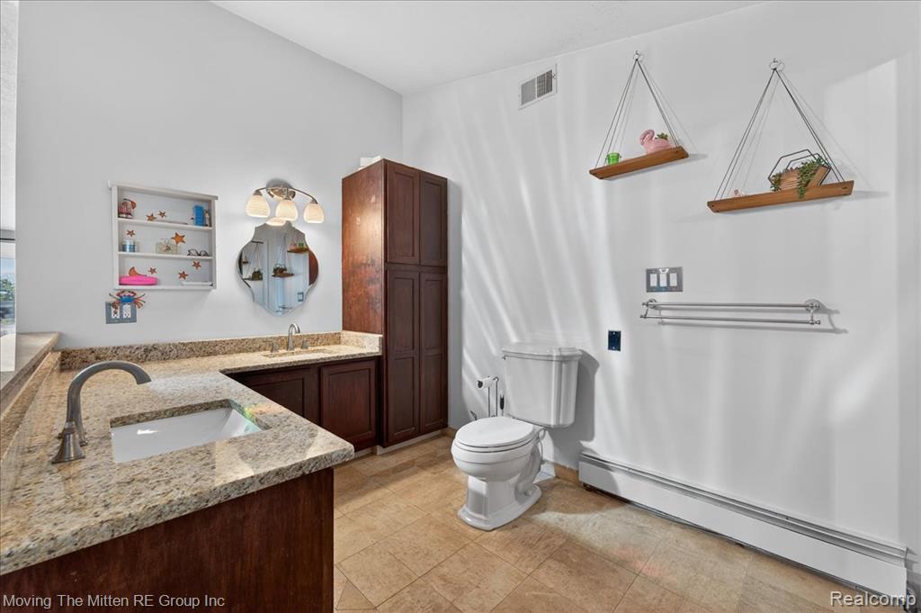 Bathroom featuring a baseboard radiator and double vanity