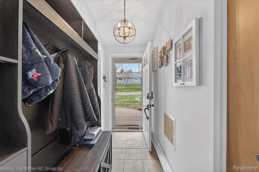 Mudroom featuring a chandelier and light tile patterned floors