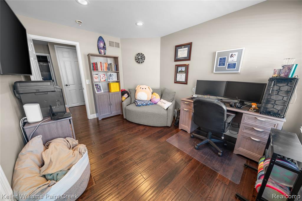 Home office with dark wood-style flooring and recessed lighting