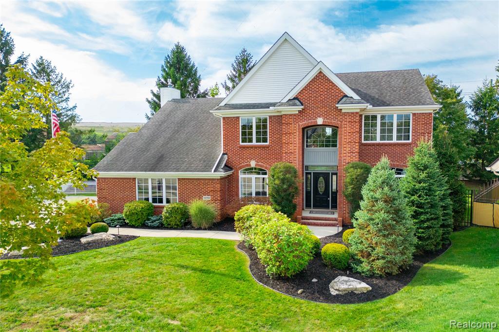 Brick exterior with white trim, featuring a prominent front entrance with an arched transom