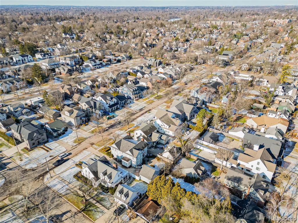 Aerial view of property and surrounding area with nearby suburban area