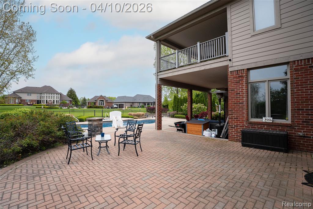 Patio / terrace featuring a patio area, an outdoor pool, and a residential view