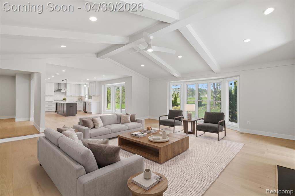 Living area with light wood finished floors, recessed lighting, ceiling fan, and beamed ceiling