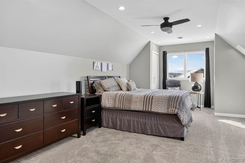 Bedroom with lofted ceiling, light carpet, ceiling fan, and recessed lighting