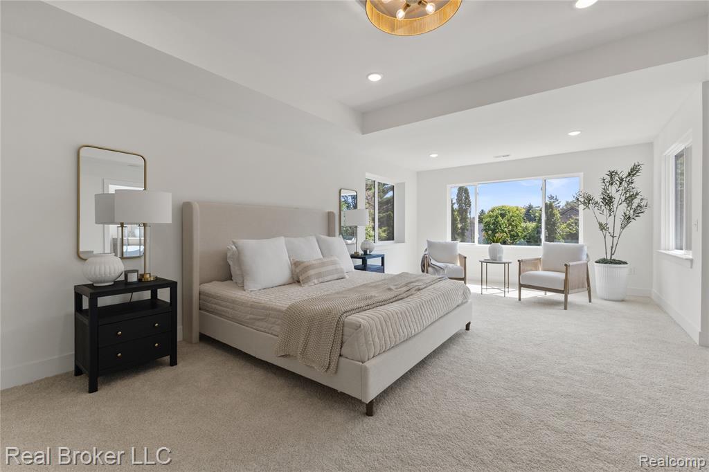 Living room featuring a premium fireplace, light wood-type flooring, a towering ceiling, and a chandelier