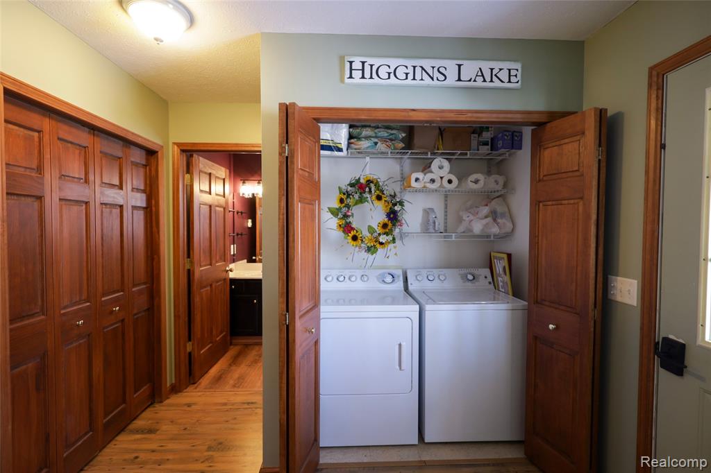 Laundry area featuring washing machine and clothes dryer and light wood finished floors