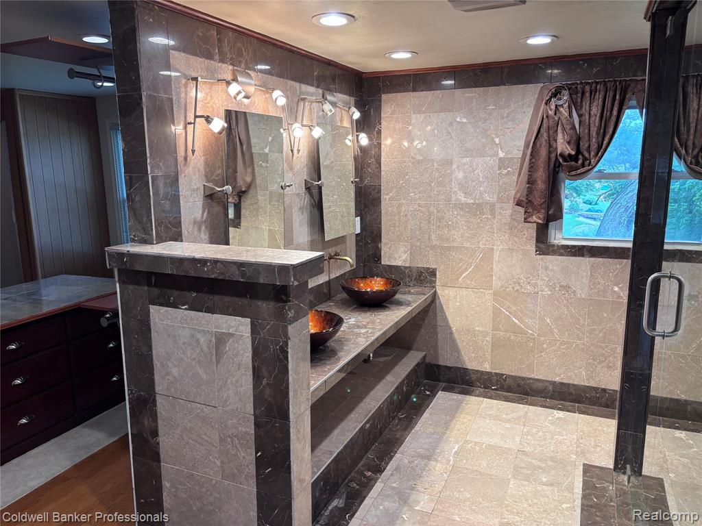 Primary bedroom Full bath featuring tile walls, vanity, a stall shower, and recessed lighting