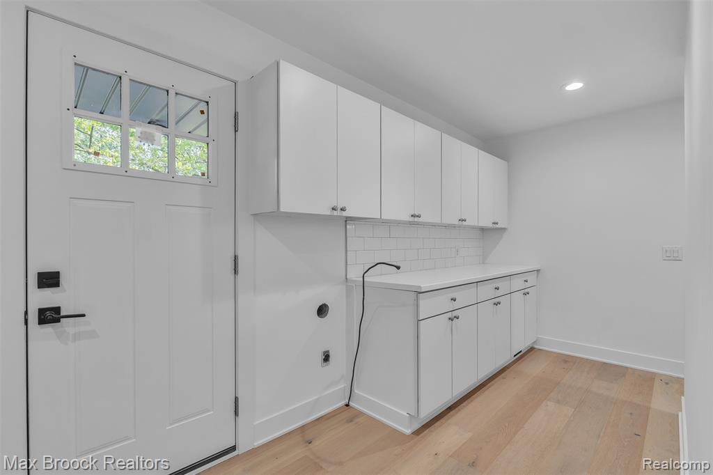Washroom with light wood-style flooring, cabinet space, hookup for an electric dryer, and recessed lighting
