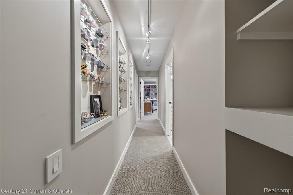 Hallway with light colored carpet and rail lighting
