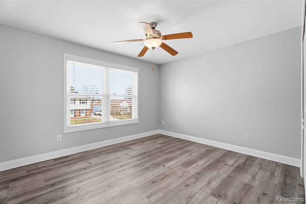 Empty room featuring a ceiling fan and light wood-style floors