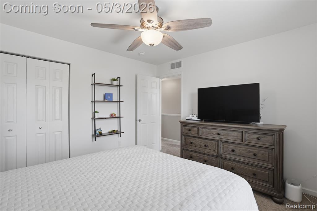 Bedroom featuring carpet flooring, ceiling fan, and a closet