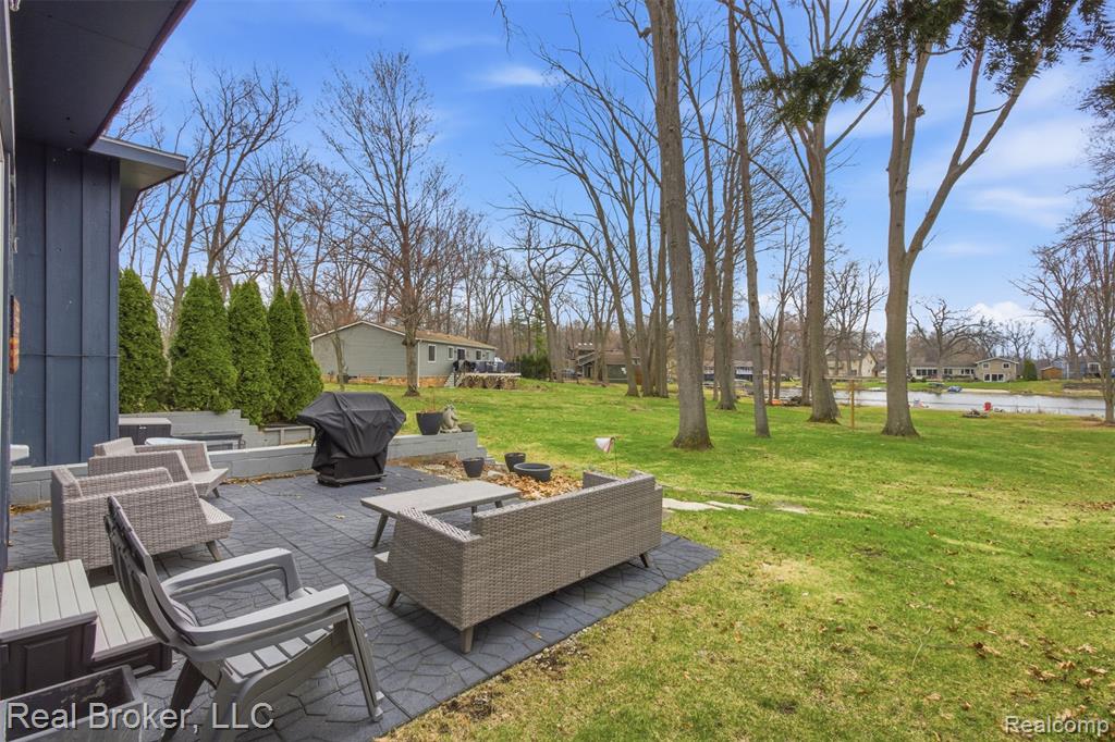 View of green lawn featuring a patio, an outdoor lounge area, and a residential view