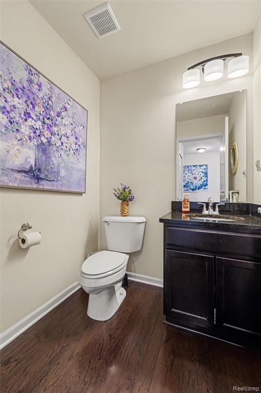 Half bath featuring vanity and dark wood-style flooring