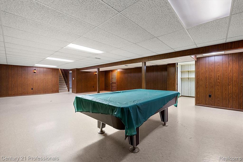 Playroom with light floors, billiards, wooden walls, and a paneled ceiling