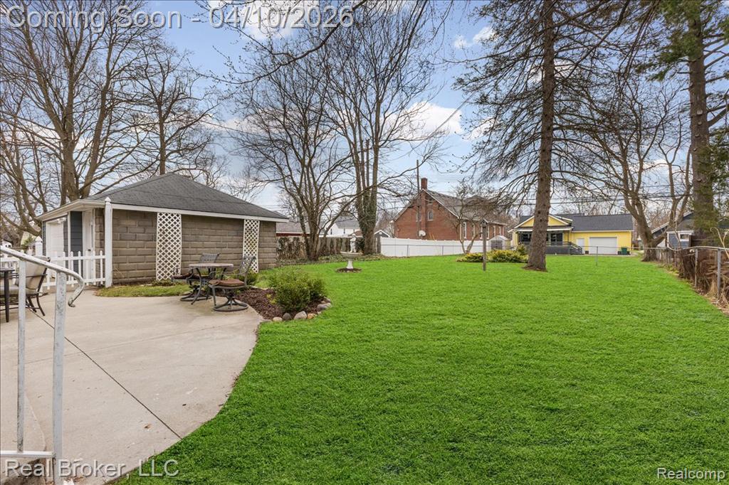 Fenced backyard featuring an outbuilding