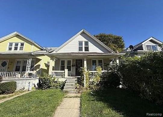 Bungalow-style home featuring covered porch and a front yard