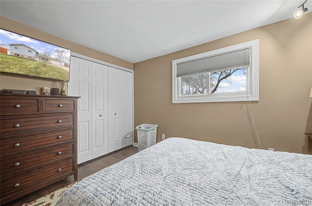 Bedroom featuring dark wood-style flooring and a closet