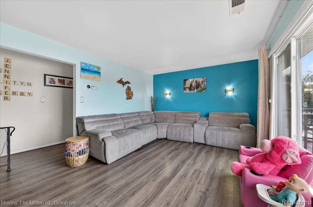 Living area with wood finished floors and an accent wall