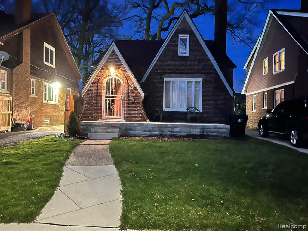 View of front of property with a yard and brick siding
