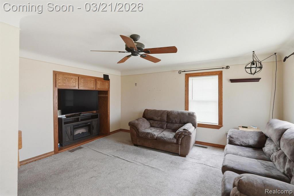 Living room featuring carpet floors and a ceiling fan