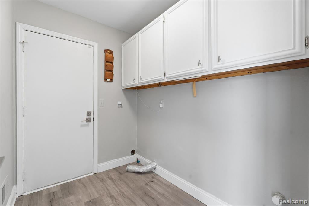Laundry room featuring light wood-style floors and cabinet space