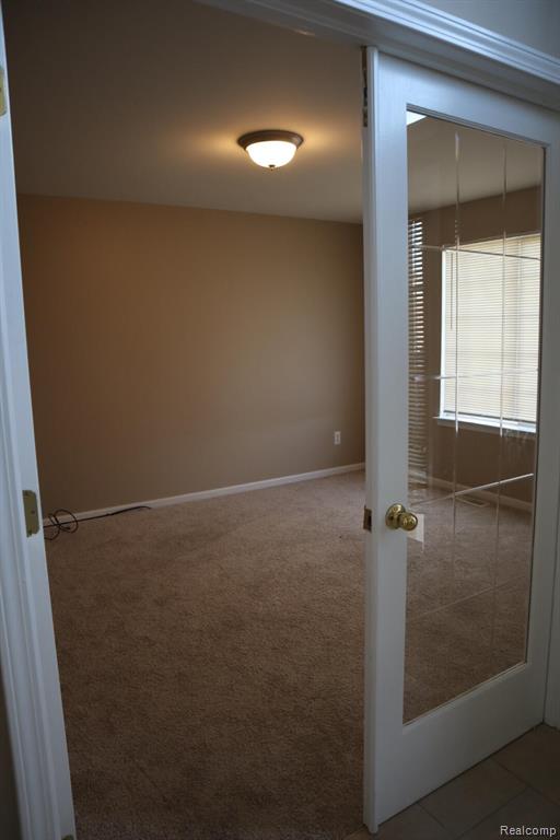 Spare room featuring baseboards and carpet flooring
