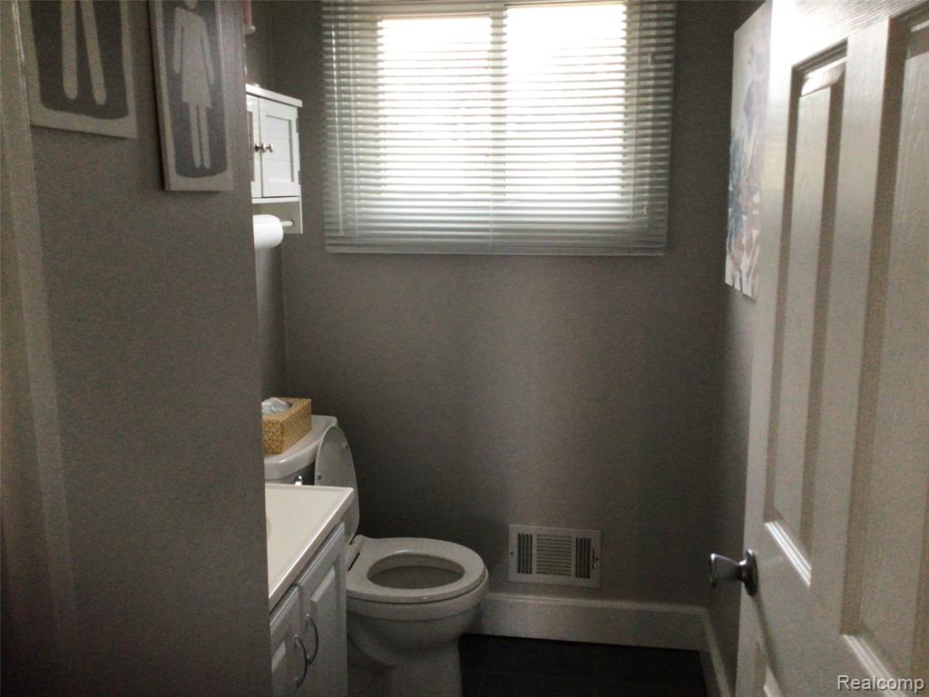 Bathroom featuring vanity and dark tile patterned flooring