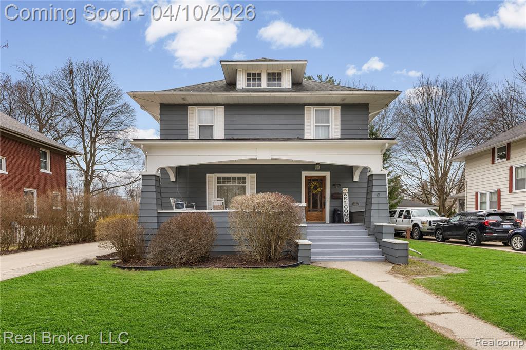 American foursquare style home with a front yard and a porch