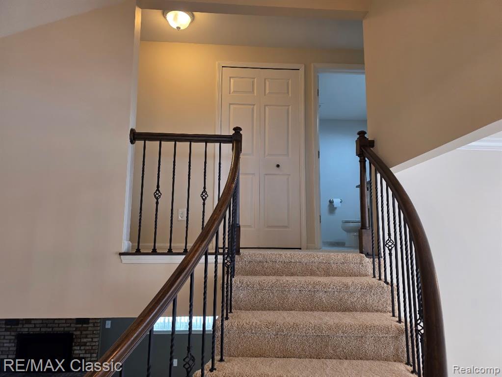Stairs with a brick fireplace