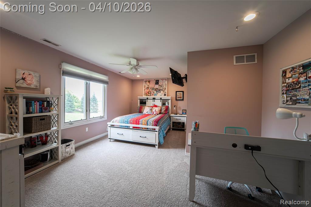 Bedroom with light colored carpet, ceiling fan, and recessed lighting