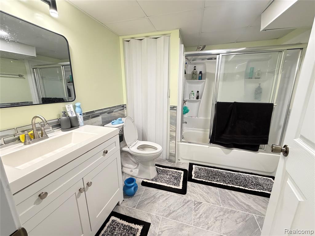 Full bathroom featuring vanity and combined bath / shower with glass door