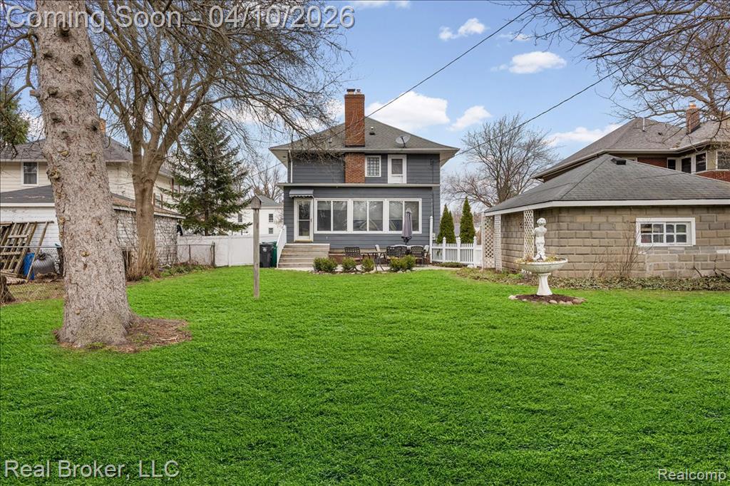 Rear view of property featuring a chimney and a sunroom