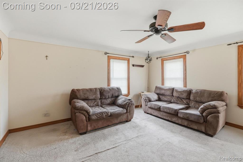 Living room featuring ceiling fan and light colored carpet