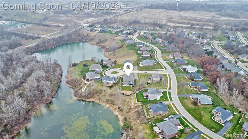 Aerial perspective of suburban area featuring a nearby body of water