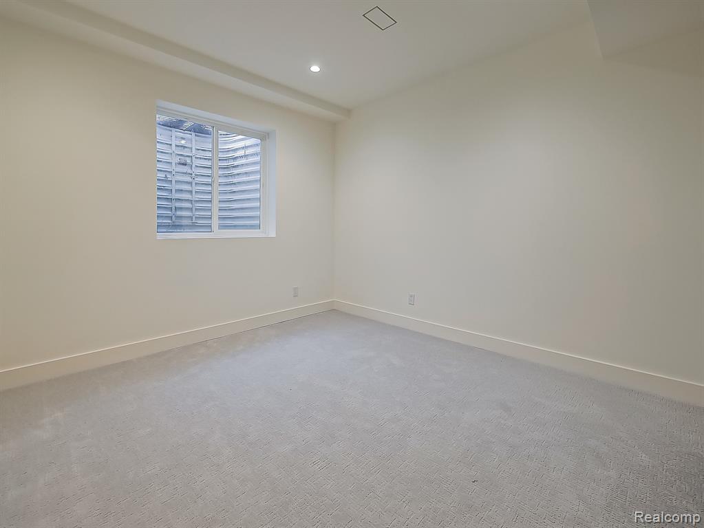 Empty room with carpet and recessed lighting